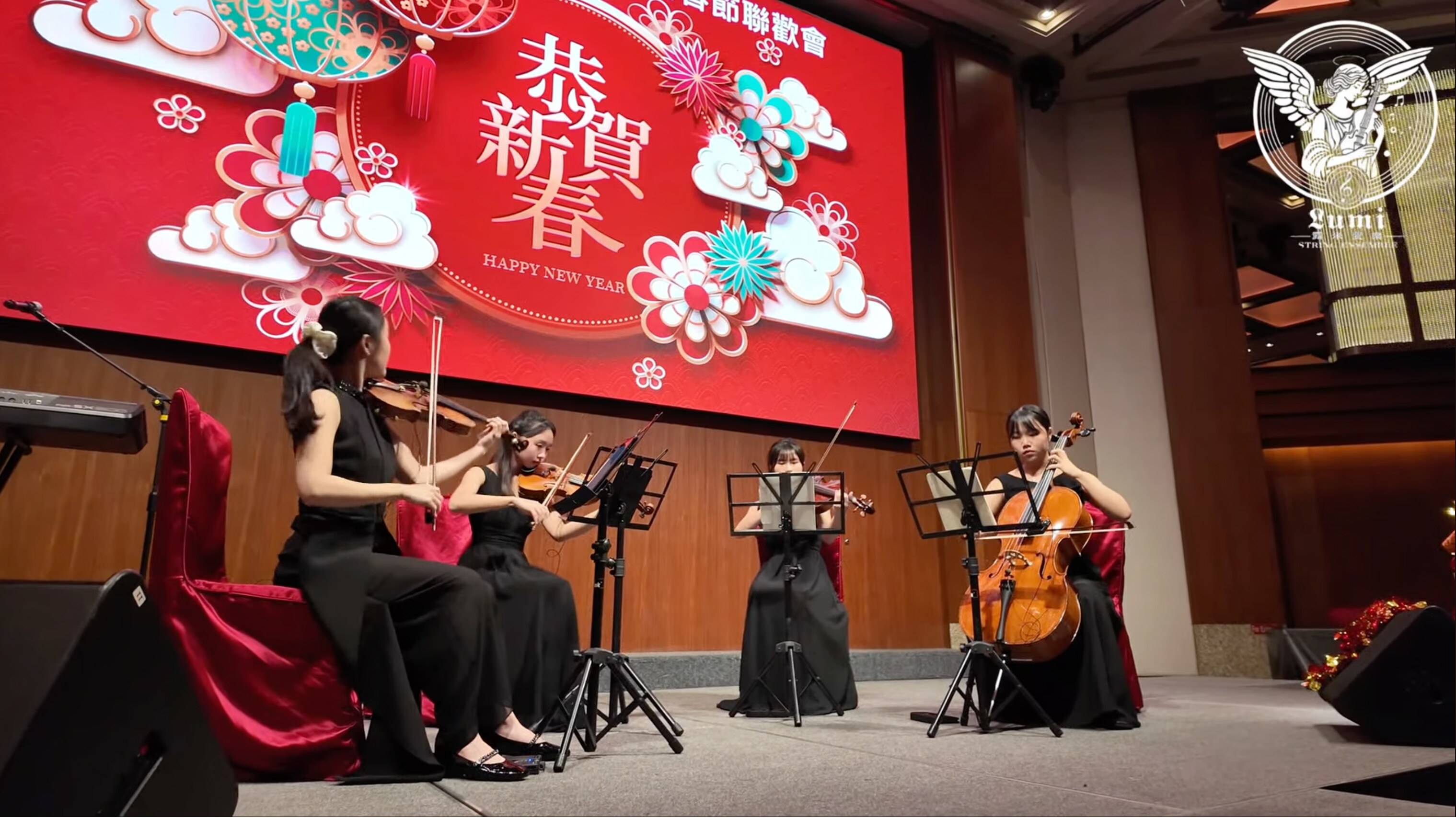 舞台現場，四位穿黑色禮服的弦樂演奏者在新年佈景前演出